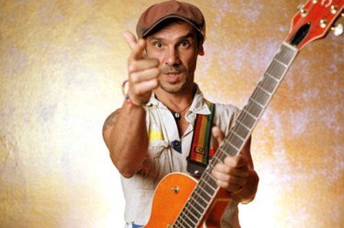 Ο Μάνου Τσάο τραγουδάει με την κιθάρα του σε πλατεία στο Παγκράτι και γύρω του χορεύουν παιδάκια 