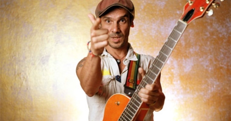 Ο Μάνου Τσάο τραγουδάει με την κιθάρα του σε πλατεία στο Παγκράτι και γύρω του χορεύουν παιδάκια 